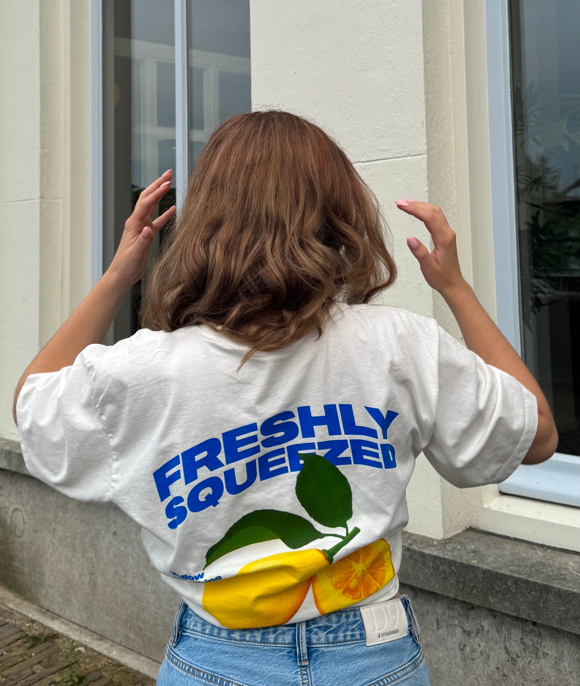 wit t-shirt met print op de achterkant van gele citroenen en blauwe tekst freshly squeezed